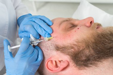 Doktor güzellik uzmanı sıkma ve bir güzellik salonu erkeklerde yüz cilt kırışıklıkları yumuşatma için gençleştirici yüz enjeksiyonları yordam bulunur. Kozmetik Cilt Bakımı.