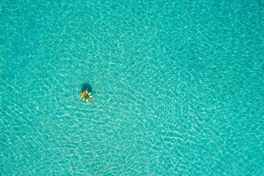 İnce kadın yüzme yüzmek halka çörek de Seyşeller şeffaf turkuaz denizin üzerinde hava görünümünü. Yaz deniz kızı, güzel dalgalar, renkli su ile. Drone üzerinden üstten görünüm