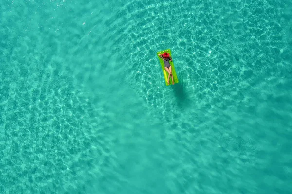 Aerial view of slim woman swimming on the swim mattress in the t — Stock Photo, Image