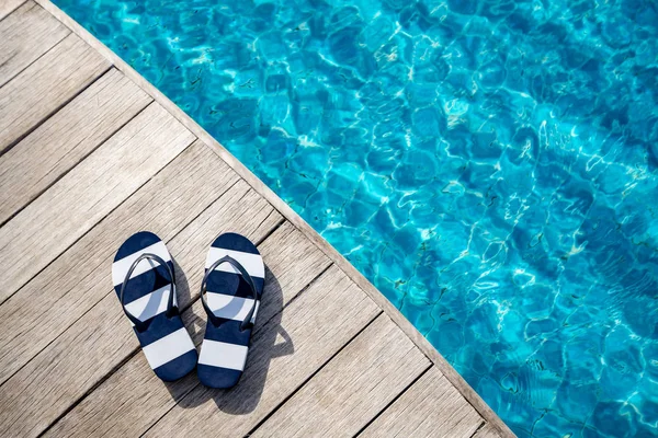 Flip flops  at the side of swimming pool, summer travel concept. — Stock Photo, Image