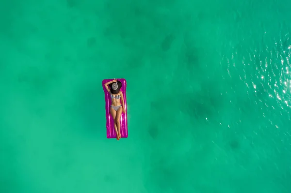 Luftaufnahme einer schlanken Frau, die auf der Badematratze in der — Stockfoto