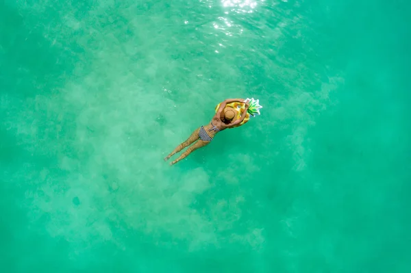 Вид с воздуха на стройную женщину, плавающую на прозрачной бирюзе — стоковое фото