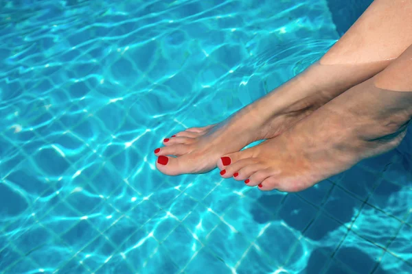 Beautiful women legs in blue water. Beautiful sexy female feet r — Stock Photo, Image