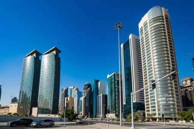 DOHA, Katar - 23 Kasım 2019: Doha, Katar 'da güzel mavi bir gökyüzü gününde Batı Körfezi Şehri silueti. Batı Körfezi, Doha 'nın en önemli bölgelerinden biridir..