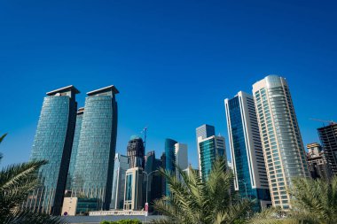 DOHA, Katar - 23 Kasım 2019: Doha, Katar 'da güzel mavi bir gökyüzü gününde Batı Körfezi Şehri silueti. Batı Körfezi, Doha 'nın en önemli bölgelerinden biridir..