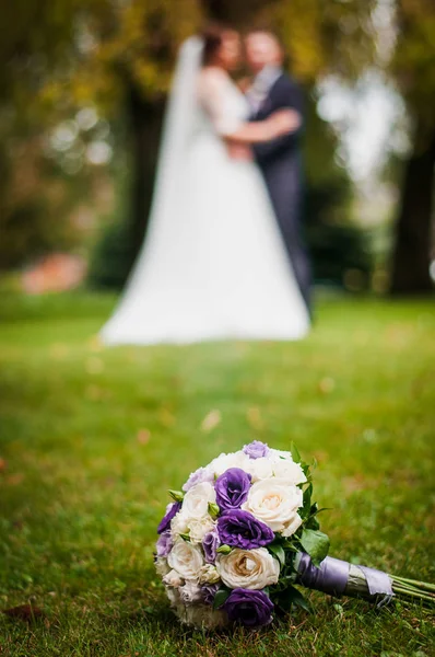 一对新婚夫妇和花束在前面的焦点 — 图库照片