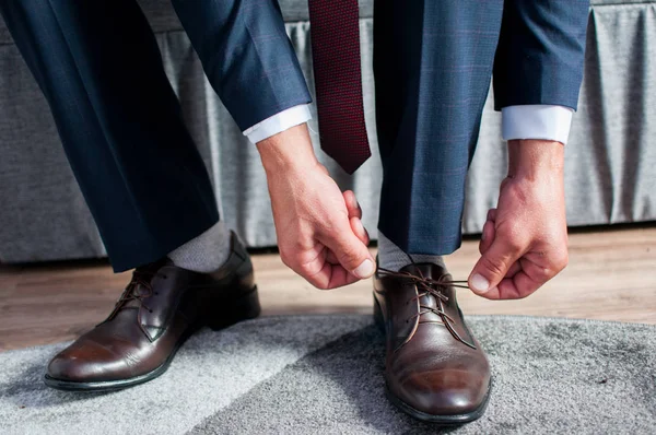 Kahverengi ayakkabı bağlı adam dantel