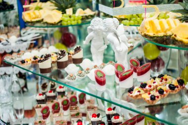 Aperatifler tatlılar ve masanın üzerine iki beyaz melek