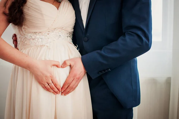 hamile kadın kocası ile kalp el simgesiyle