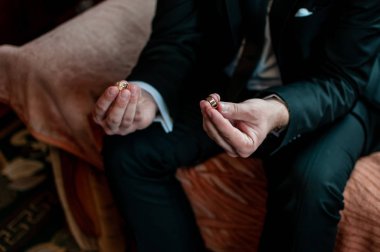 Alyans her iki elinde tutan damat