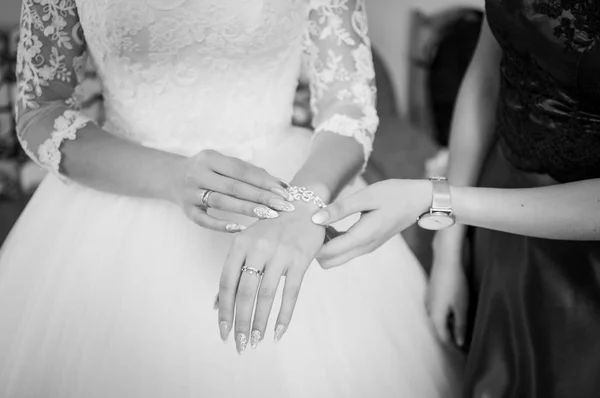 Dama de honor ayuda a usar pulsera en la mano de las novias — Foto de Stock