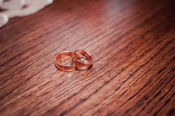 木桌上的一对金结婚戒指 — 图库照片