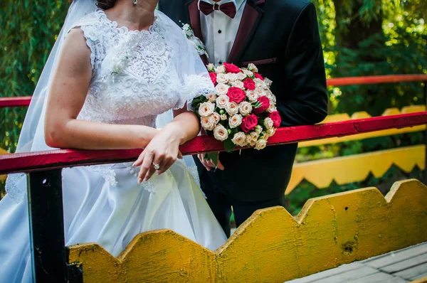 Novia y novio sosteniendo colorido ramo de boda en la mano —  Fotos de Stock