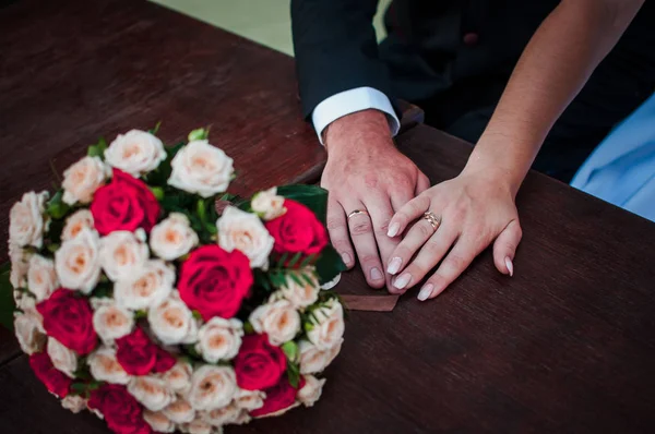 新娘和新郎手与花束在桌子上 — 图库照片