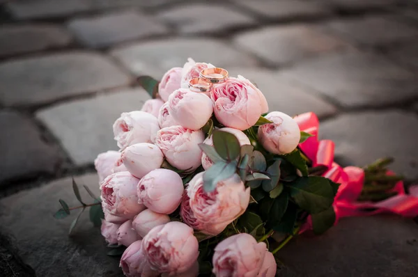 Bagues de mariage en or sur le bouquet de fleurs — Photo