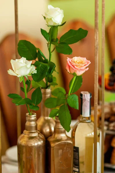 Rose nelle bottiglie d'oro e una bottiglia di vino — Foto Stock