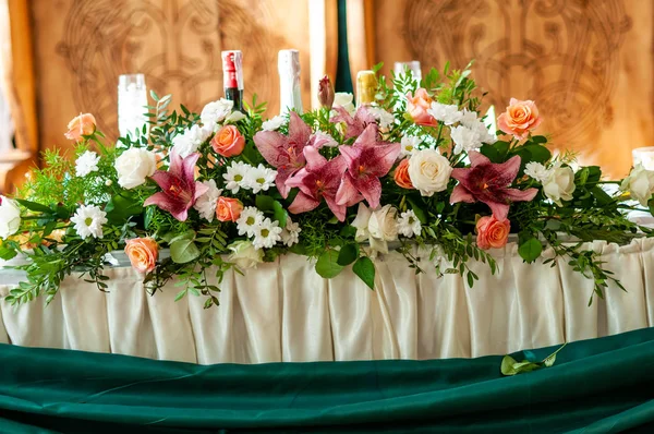 Blommor dekorera ett bord med flaskor i bakgrunden — Stockfoto