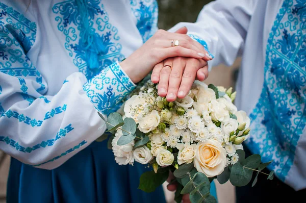 Γαμπρός και τη νύφη κρατώντας τα χέρια για το μπουκέτο των λουλουδιών — Φωτογραφία Αρχείου