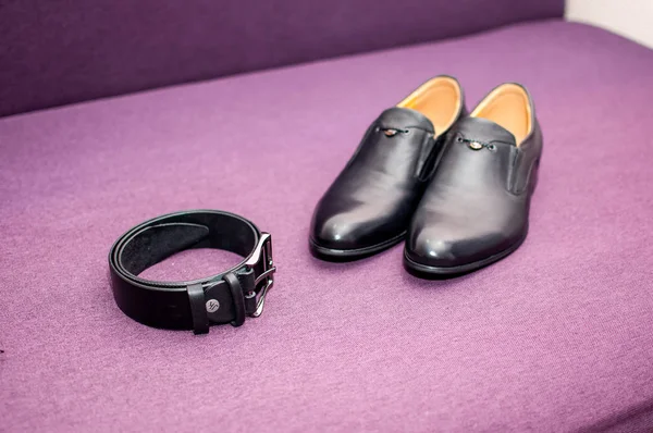 Fekete övet és fekete cipőt a lila kanapén — Stock Fotó