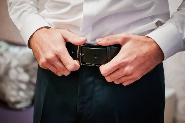Close up man holding hands on his belt