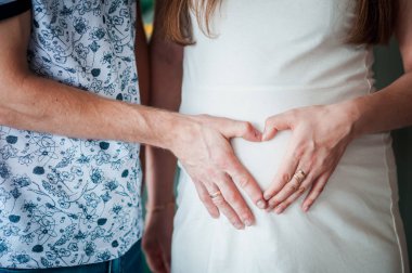 Beyaz elbise ve adam sarılmak göbek hamile kadın