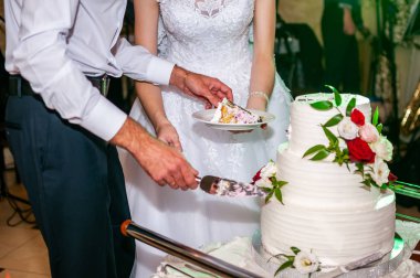 Gelin ve damat beyaz düğün pastası kesme