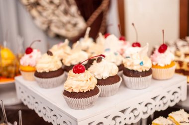 Beyaz stand üzerinde beyaz tatlı cupcakes