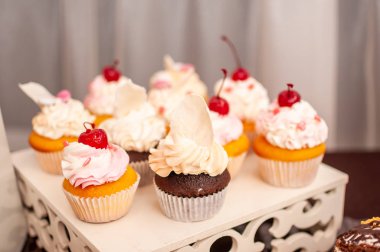 Beyaz stand üzerinde beyaz tatlı cupcakes