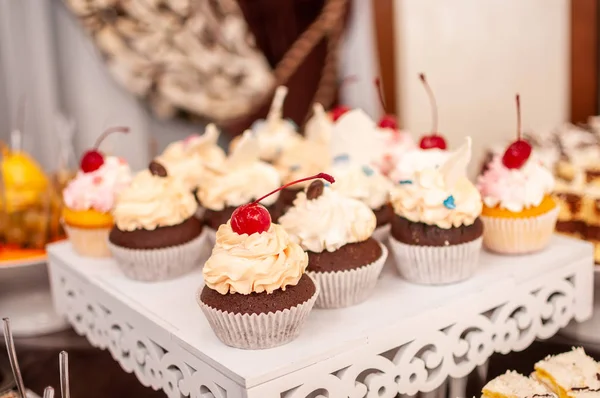 Cupcakes sucrés blancs sur le stand blanc — Photo