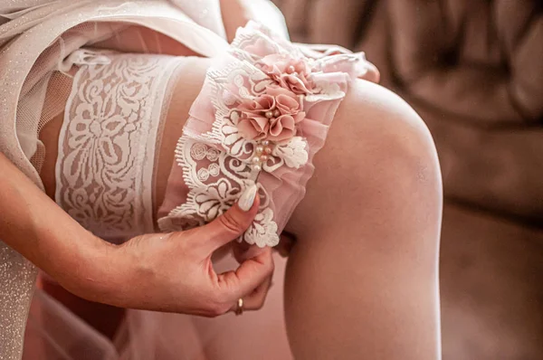 Wedding red and blue garter on the brides leg — Stock Photo, Image