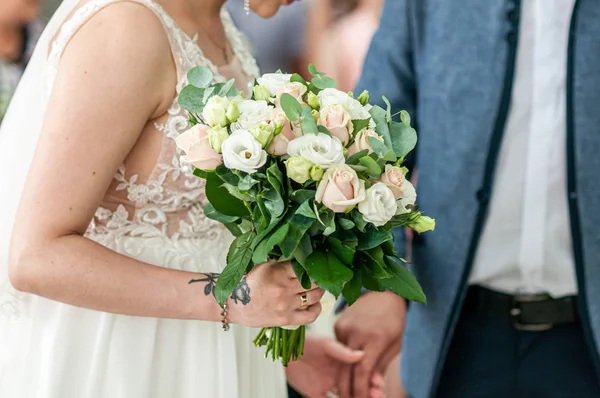 Witte bloemen in de hand van de bruid — Stockfoto