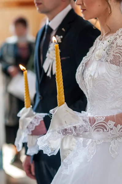 Noiva e noivo segurando velas na igreja — Fotografia de Stock