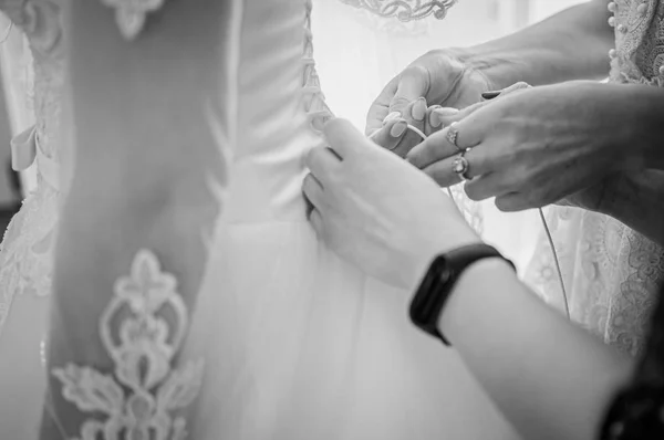 bridesmaids lace up the bride's dress black and white