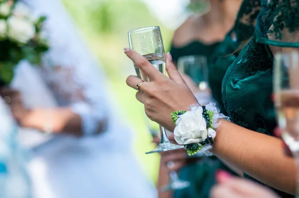 Κορίτσι με πράσινο φόρεμα και τριαντάφυλλο στο χέρι κρατώντας ποτήρι σαμπάνιας — Φωτογραφία Αρχείου