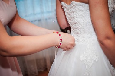 Nedimeler gelinin gelinlik giymesine yardım ediyor