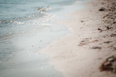 deniz dalgası kumlu kıyıyı yıkıyor