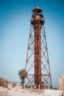 Dzharylgach adasında sahilde eski terk edilmiş çelik paslı deniz feneri