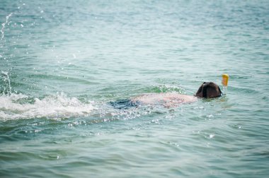 Okyanusta şnorkel maskesi ile yüzen adam