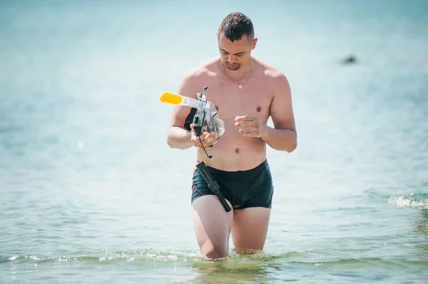 Man met zwem masker in de hand gaat op water — Stockfoto
