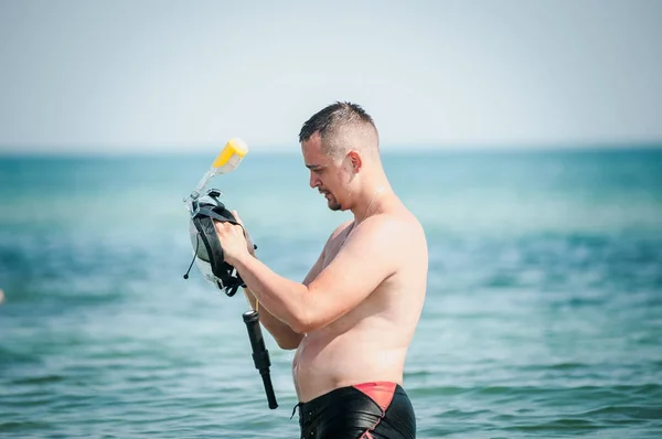 Man zet op een snorkel masker in de Oceaan — Stockfoto