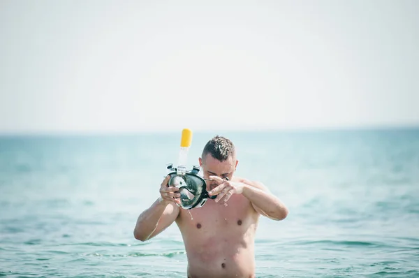 El hombre con la máscara de nadar en la mano va en el agua —  Fotos de Stock