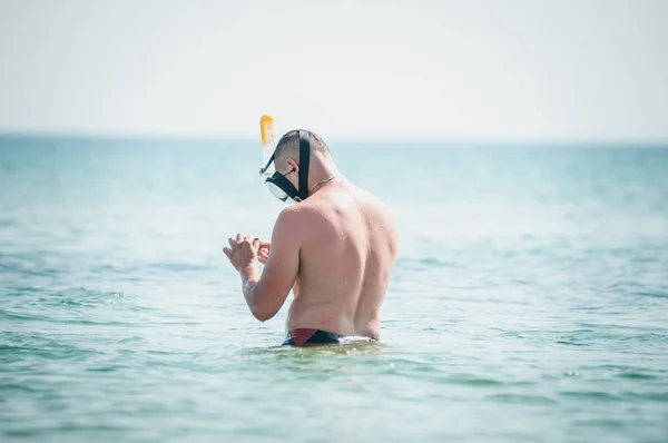 El hombre con la máscara de nadar en la mano va en el agua —  Fotos de Stock