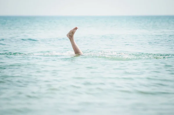 Het been van de mens steekt uit het water — Stockfoto