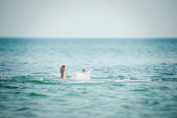 De benen van de man steken uit het water — Stockfoto