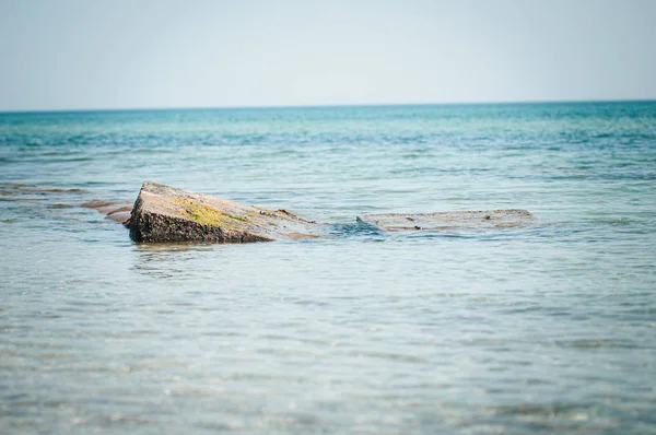 Oude betonnen blokken in het zeewater — Stockfoto