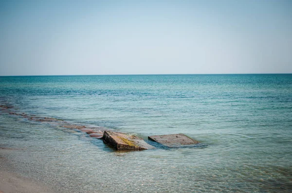 Oude betonnen blokken in het zeewater — Stockfoto