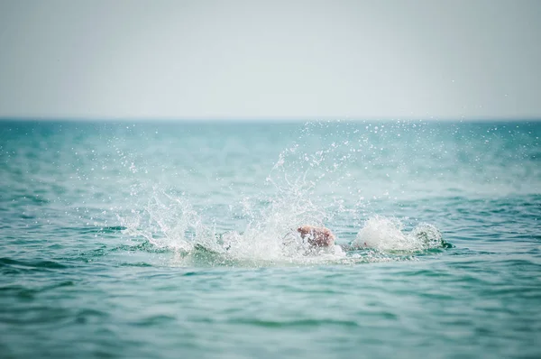 De benen van de man steken uit het water — Stockfoto