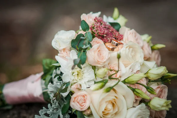 Anéis de casamento de ouro no buquê de flores — Fotografia de Stock