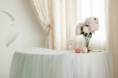 Mum ve çiçek buketli beyaz masa.