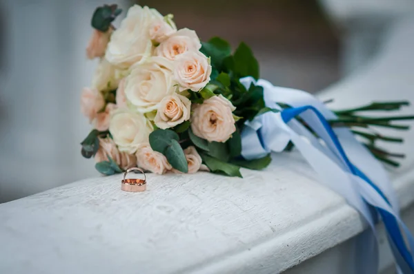 黄金の結婚指輪とバラの花束 — ストック写真